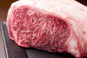 Marbled A5 Wagyu loin cut showing intricate fat patterns on a dark plat