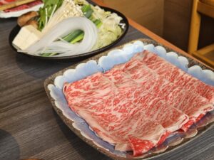 Plates of Kobe and Matsusaka Wagyu beef prepared for sukiyaki with vegetables