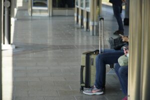 Foreign travelers waiting with luggage at a station, illustrating booking confusion in Japan 