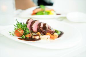 Plated lean Wagyu steak with seasonal vegetables, presented in a refined, minimalist style