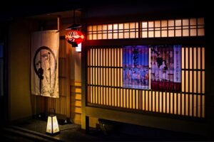 Tokyo dining entrance with wooden lattice doors, illuminated lantern and noren curtain, suggesting a traditional, intimate Wagyu experience.